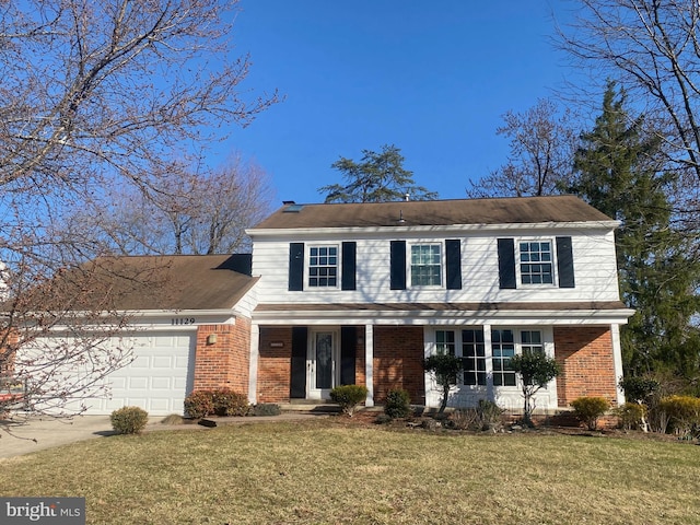 traditional home featuring brick siding, a garage, and a front lawn