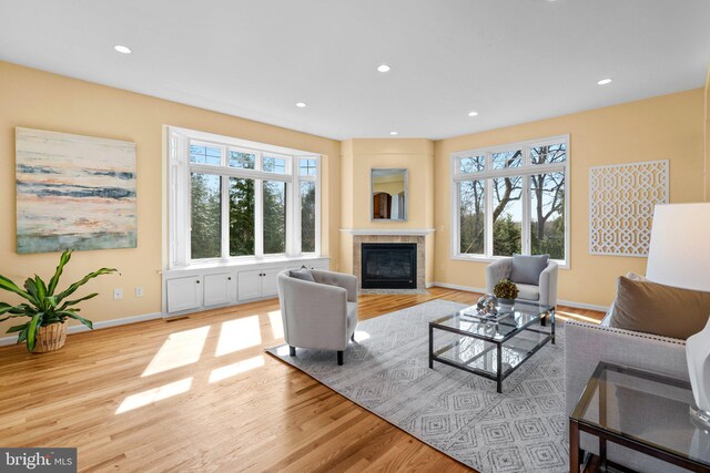 living room with recessed lighting, wood finished floors, and a fireplace