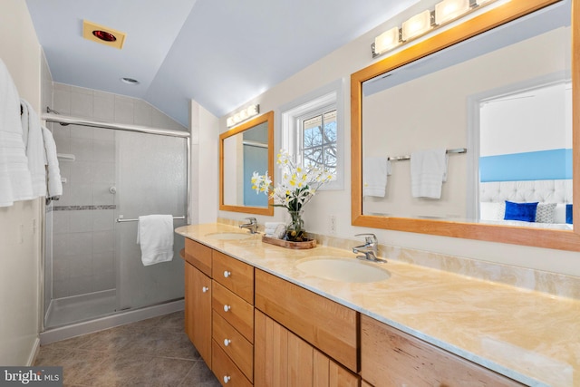 bathroom with tile patterned flooring, double vanity, a stall shower, and a sink