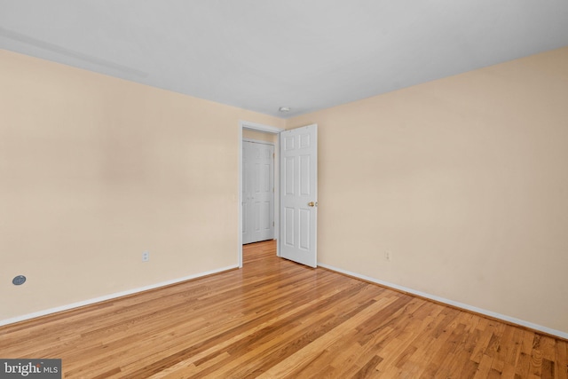 empty room with baseboards and light wood-style floors