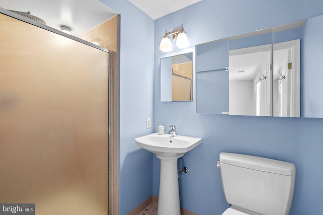 bathroom featuring toilet and a shower stall