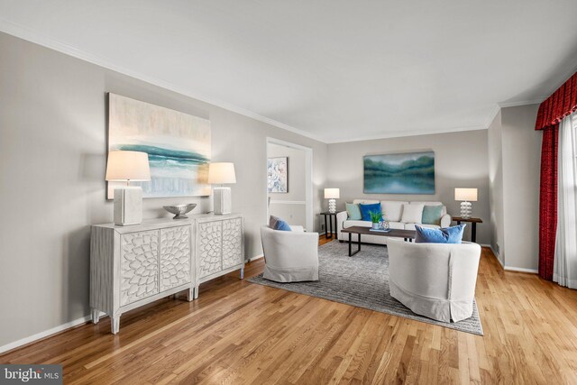 living room with baseboards, light wood finished floors, and ornamental molding