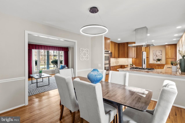 dining space with recessed lighting, light wood-style floors, and baseboards