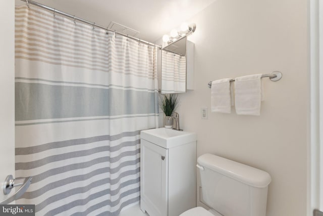 bathroom featuring vanity, toilet, and a shower with curtain