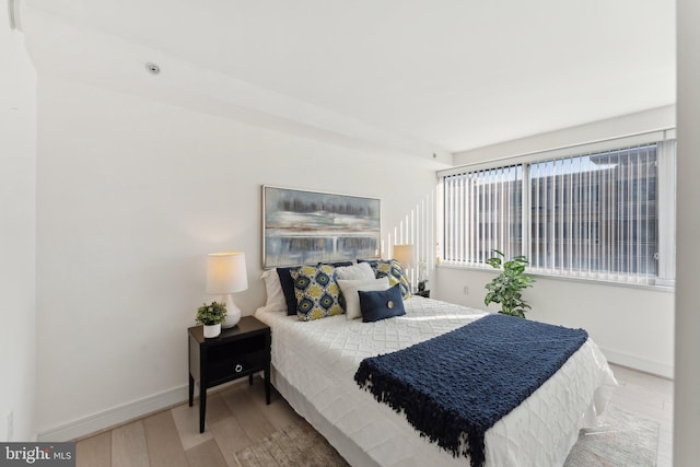 bedroom with baseboards and wood finished floors