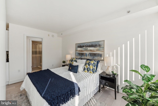 bedroom featuring baseboards and wood finished floors