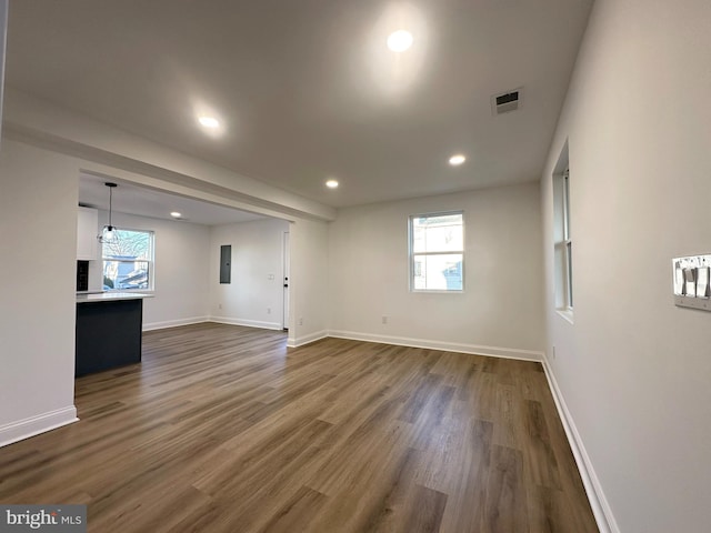 spare room featuring dark wood finished floors, visible vents, and baseboards