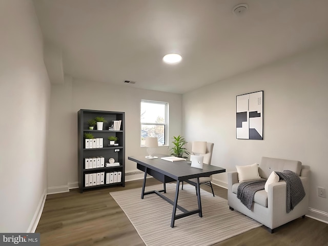 home office featuring visible vents, baseboards, and wood finished floors