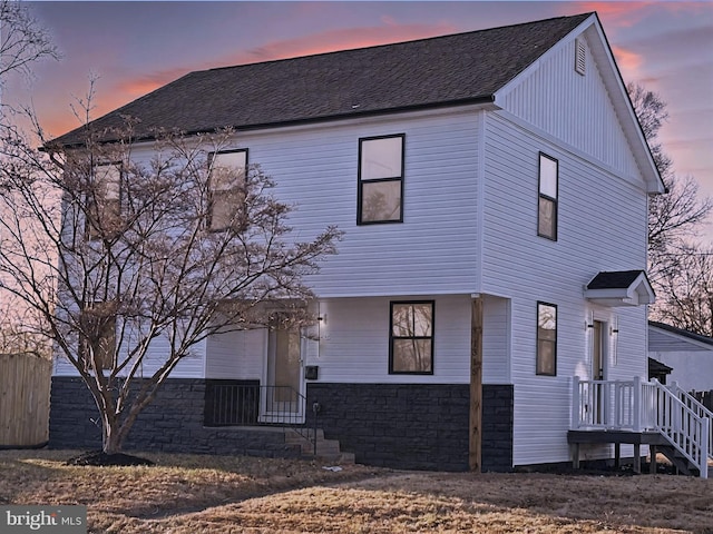 view of front of property with a shingled roof, fence, and board and batten siding