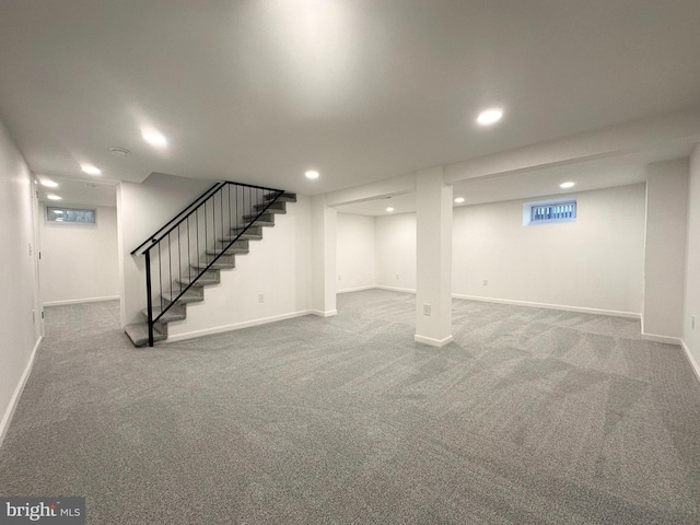 below grade area featuring carpet, stairs, baseboards, and recessed lighting