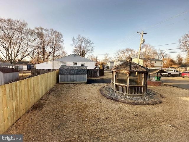 view of yard featuring an outbuilding, fence, and a shed