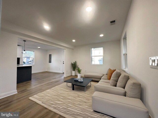 living area featuring baseboards, visible vents, dark wood-type flooring, and recessed lighting