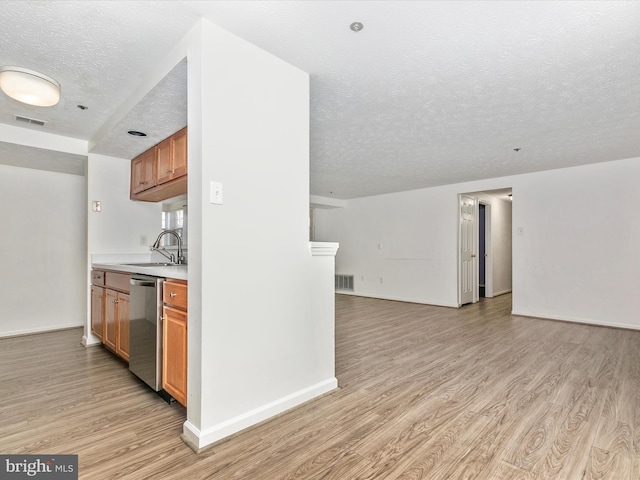 kitchen featuring open floor plan, a sink, visible vents, and stainless steel dishwasher