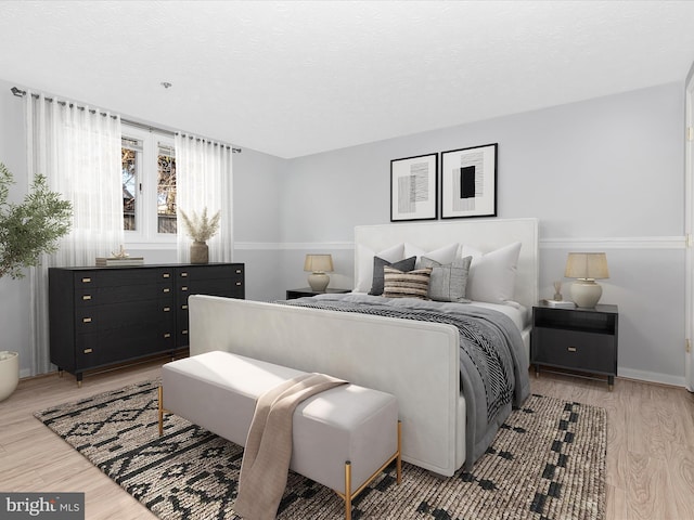 bedroom featuring a textured ceiling and light wood finished floors