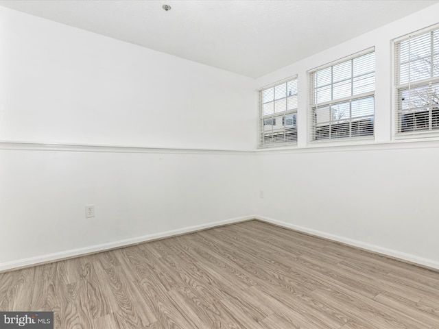 empty room featuring light wood-type flooring and baseboards