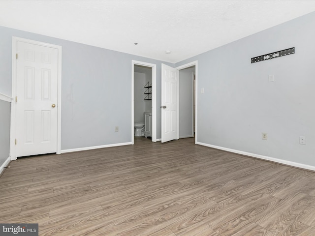 unfurnished room with light wood-style flooring and baseboards