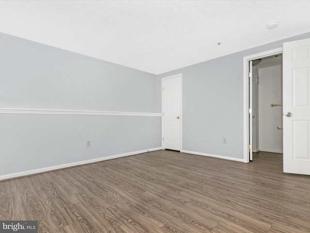 unfurnished bedroom with baseboards and wood finished floors