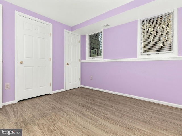 unfurnished bedroom with visible vents, baseboards, and light wood-style flooring