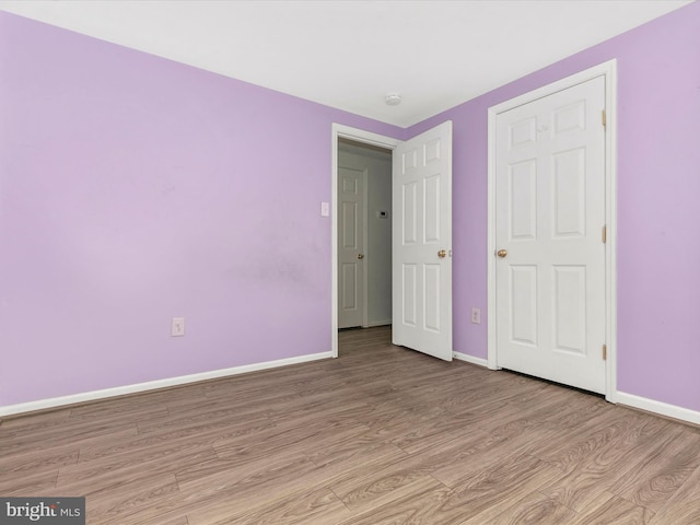 unfurnished bedroom with light wood-style flooring and baseboards