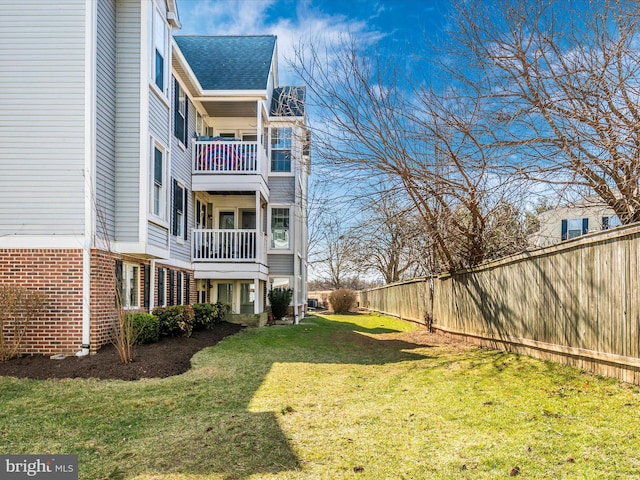 view of yard featuring a balcony and fence