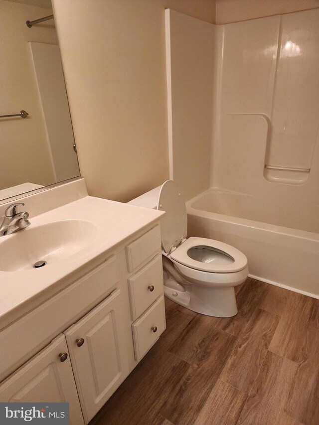 full bath with vanity, shower / bathing tub combination, toilet, and wood finished floors
