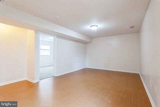 unfurnished room with visible vents, light wood-style flooring, and baseboards