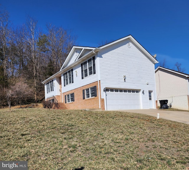 view of side of property with an attached garage, brick siding, driveway, and a yard