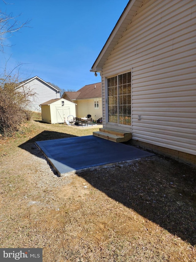 view of yard with a storage shed, an outdoor structure, and a patio