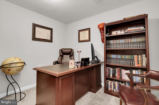office featuring baseboards and light carpet