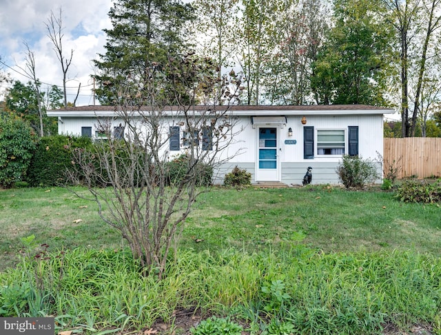 ranch-style house featuring fence and a front yard