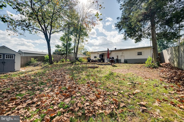 view of yard featuring a fenced backyard, an outdoor structure, and a storage unit