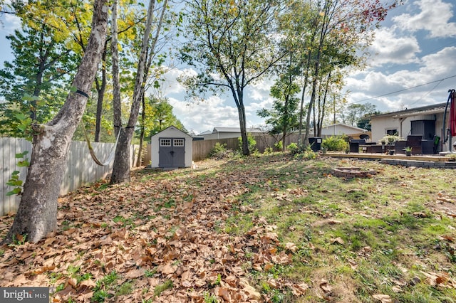 view of yard with an outbuilding, a fenced backyard, and a shed