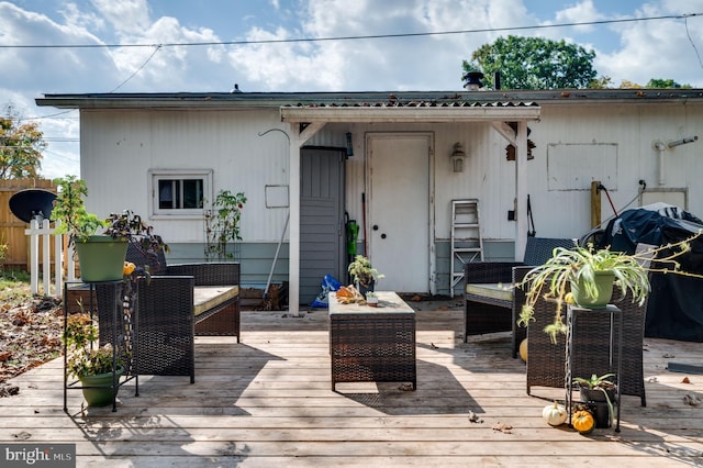 wooden terrace with grilling area, outdoor lounge area, and fence