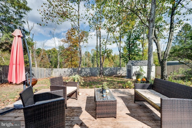 view of patio / terrace with a shed, outdoor lounge area, a fenced backyard, and an outbuilding