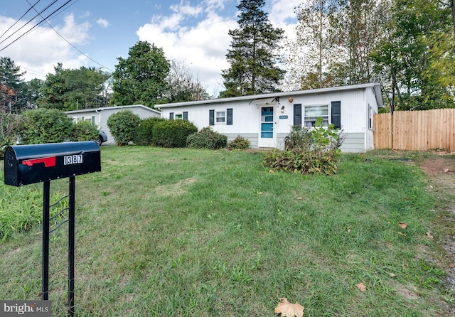 single story home featuring fence and a front lawn