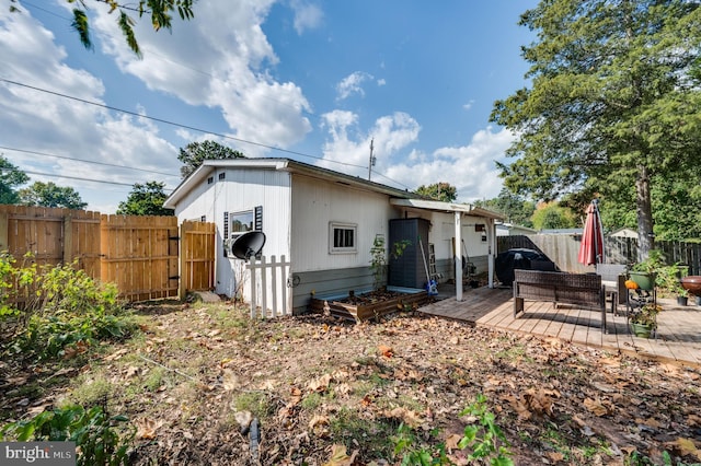 rear view of property featuring a fenced backyard and a deck