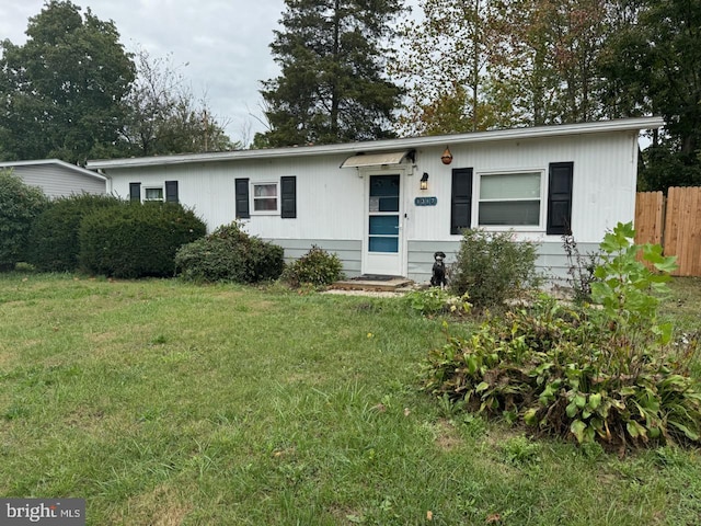 ranch-style home with fence and a front lawn