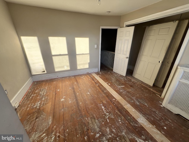 unfurnished bedroom featuring baseboards and hardwood / wood-style floors