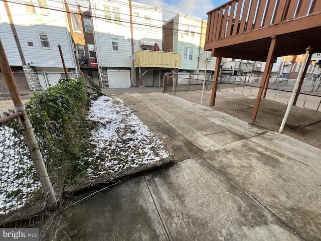 view of patio with driveway, an attached garage, and fence