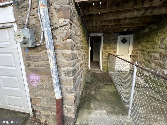 entrance to property with a garage and stone siding