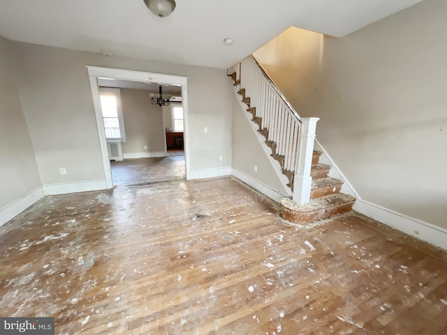 interior space with a notable chandelier, baseboards, and stairs