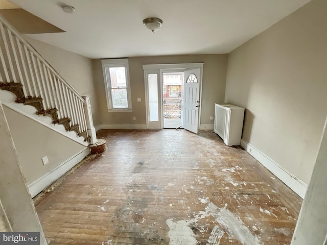 entryway featuring stairs, radiator heating unit, and baseboards