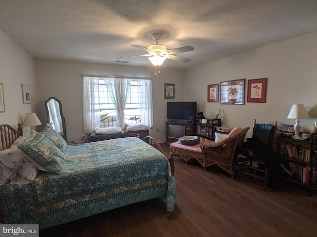 bedroom with ceiling fan, visible vents, and wood finished floors