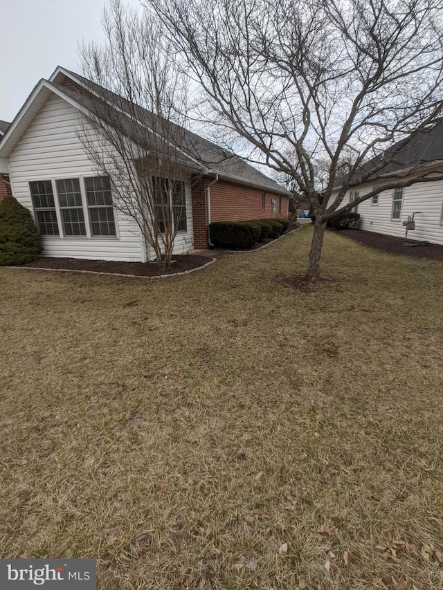 exterior space with a yard and brick siding