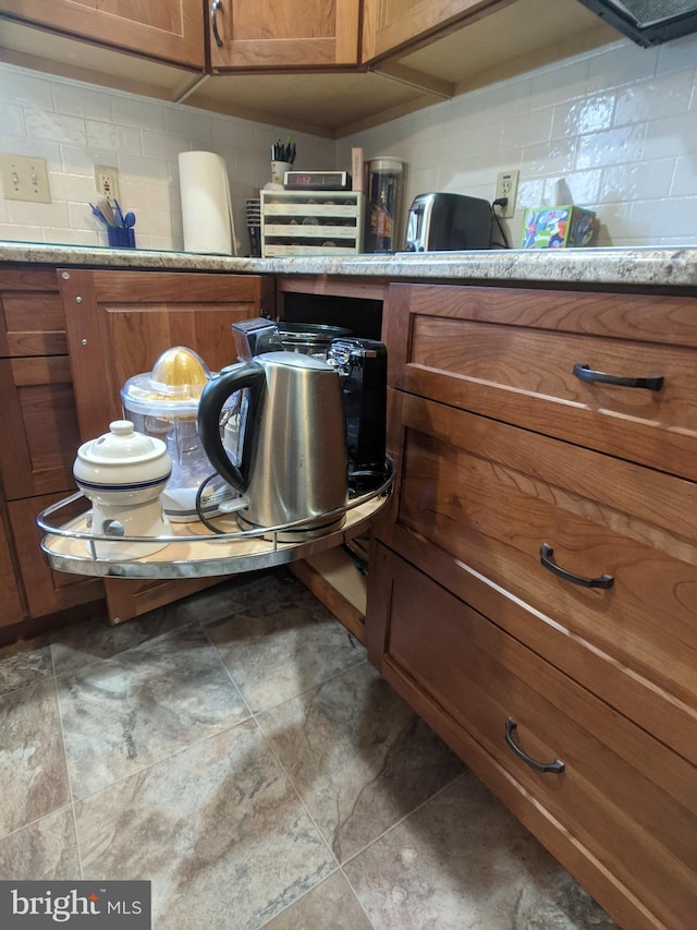 room details with brown cabinets, decorative backsplash, and light countertops