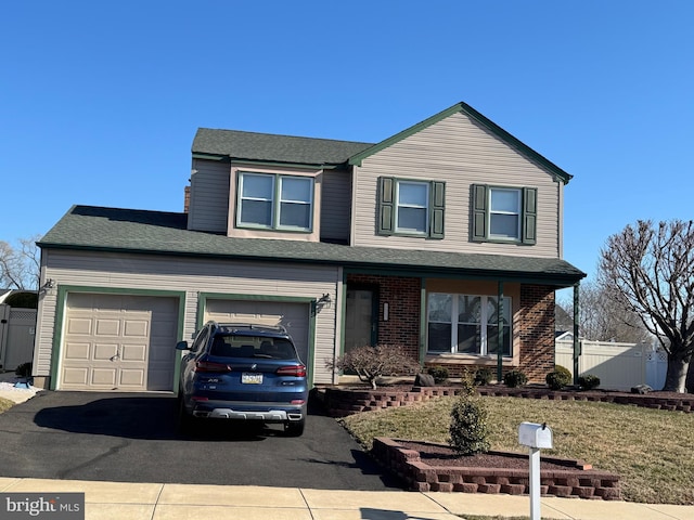 traditional home with fence, brick siding, and driveway