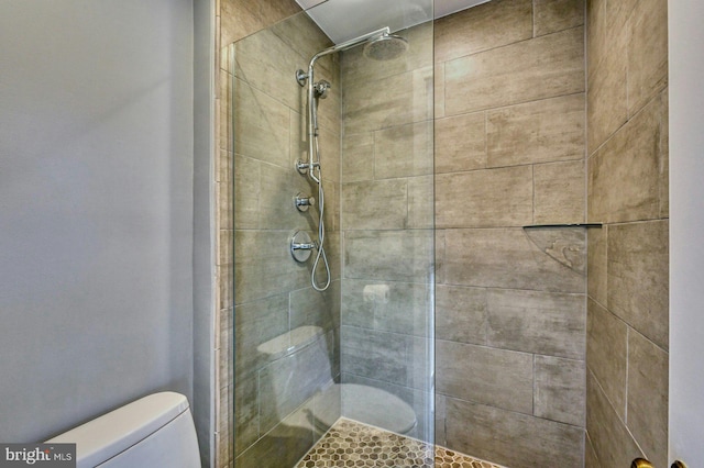 full bathroom with tiled shower and toilet