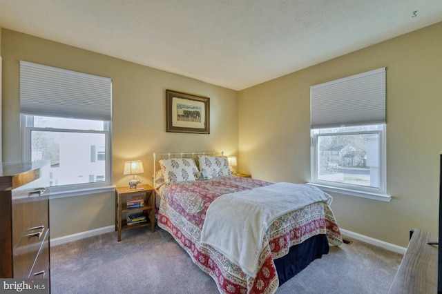 carpeted bedroom featuring multiple windows and baseboards