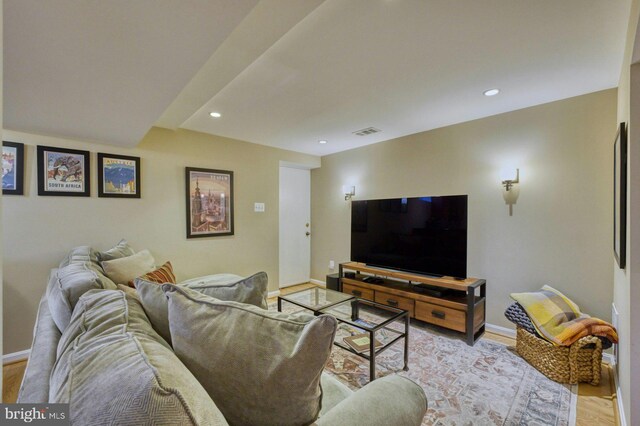 living area with visible vents, light wood-style flooring, and baseboards