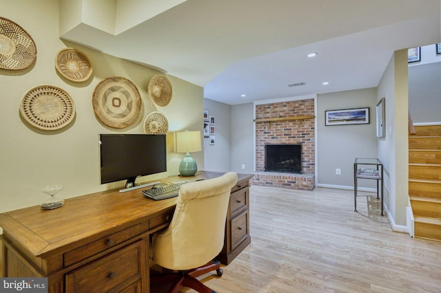 office with visible vents, baseboards, recessed lighting, a fireplace, and light wood-type flooring